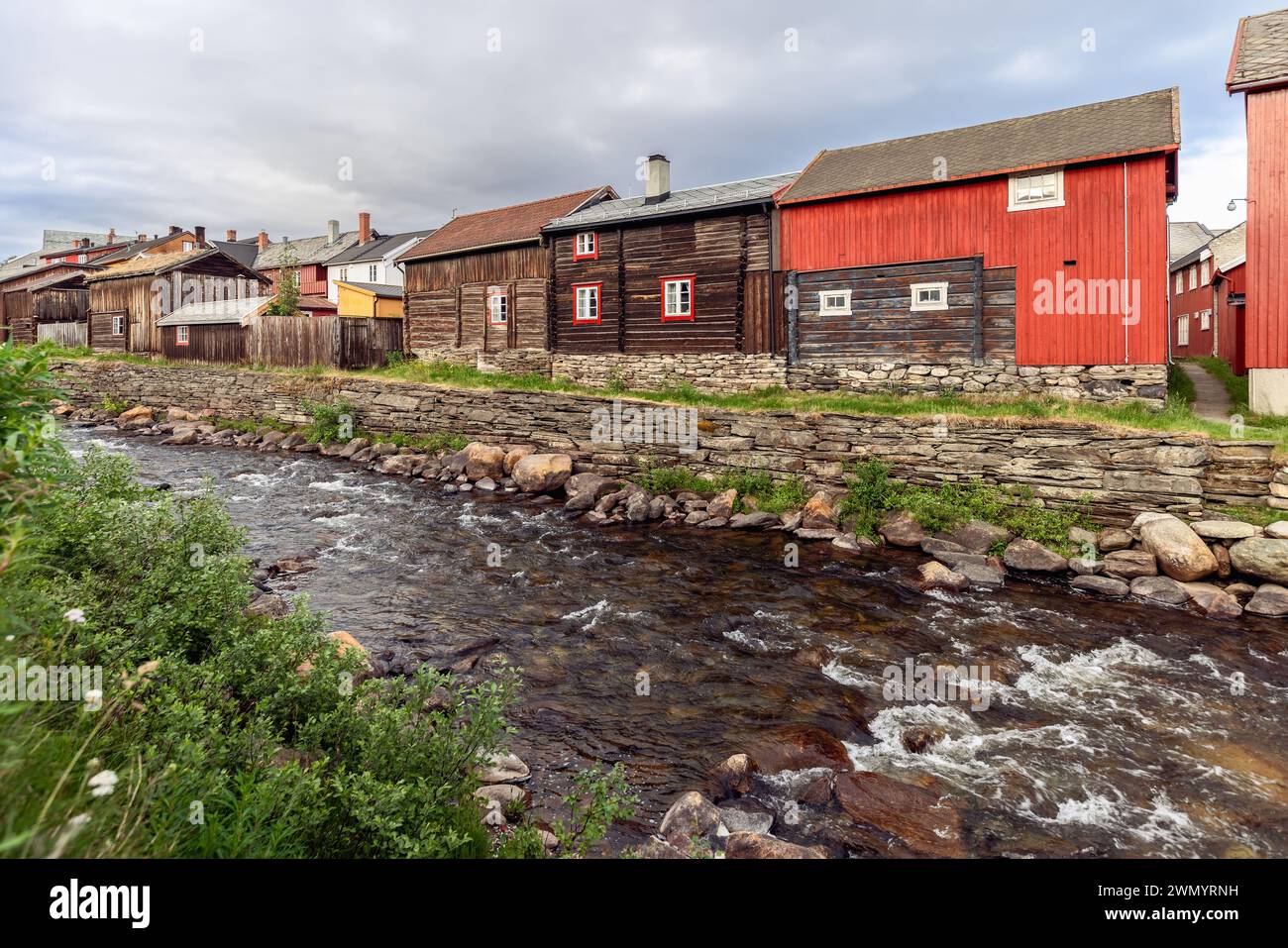 The heritage-rich landscape of Roros unfolds along the Glomma River, featuring traditional timber homes with red accents Stock Photo