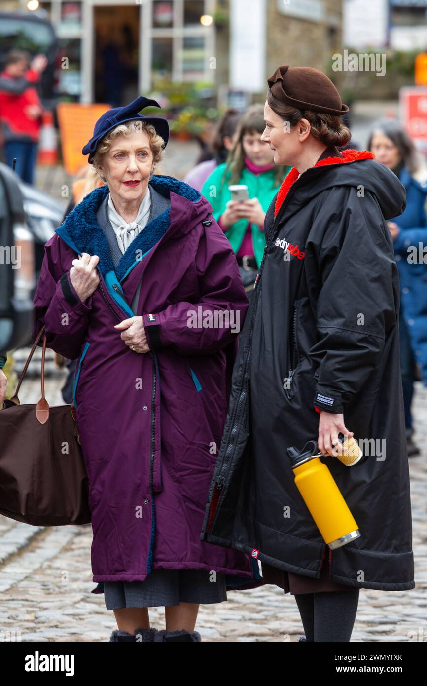 Grassington, Yorkshire, UK. 28th February 2024. Location filming begins for series 5 of the popular Channel 5 and PBS show All Creatures Great & Small. Cast and crew were spotted on the streets of the small Yorkshire Dales town of Grassington, which is converted, twice a  year, in to the fictional town of Darrowby. Pictured - Anna Madeley (Mrs Audrey Hall) and Patricia Hodge (Mrs. Pumphrey) arrive on set to film an indoor scene. Credit: Tom Holmes Photography / Alamy Live News). Stock Photo