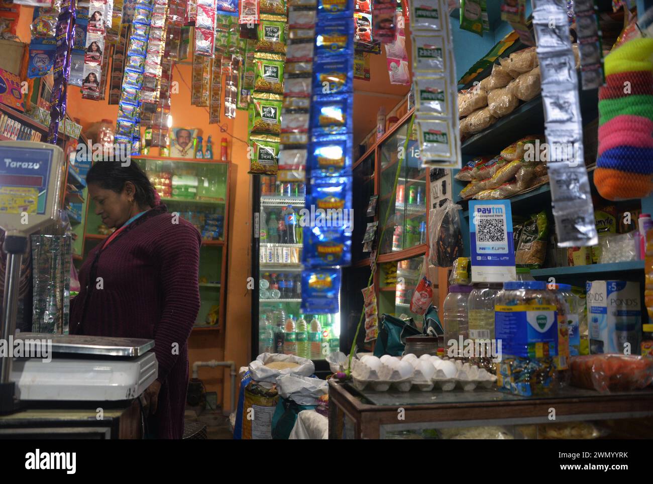 Silguri, West Bengal, India. 28th Feb, 2024. A shopkeeper is seen at her grocery store next to the display of QR code for Paytm for digital payment platform for payment transactions in Siliguri.The Reserve Bank of India (RBI) ordered the closure of Paytm Payments Bank due to non-compliance and supervisory concerns. (Credit Image: © Diptendu Dutta/ZUMA Press Wire) EDITORIAL USAGE ONLY! Not for Commercial USAGE! Stock Photo