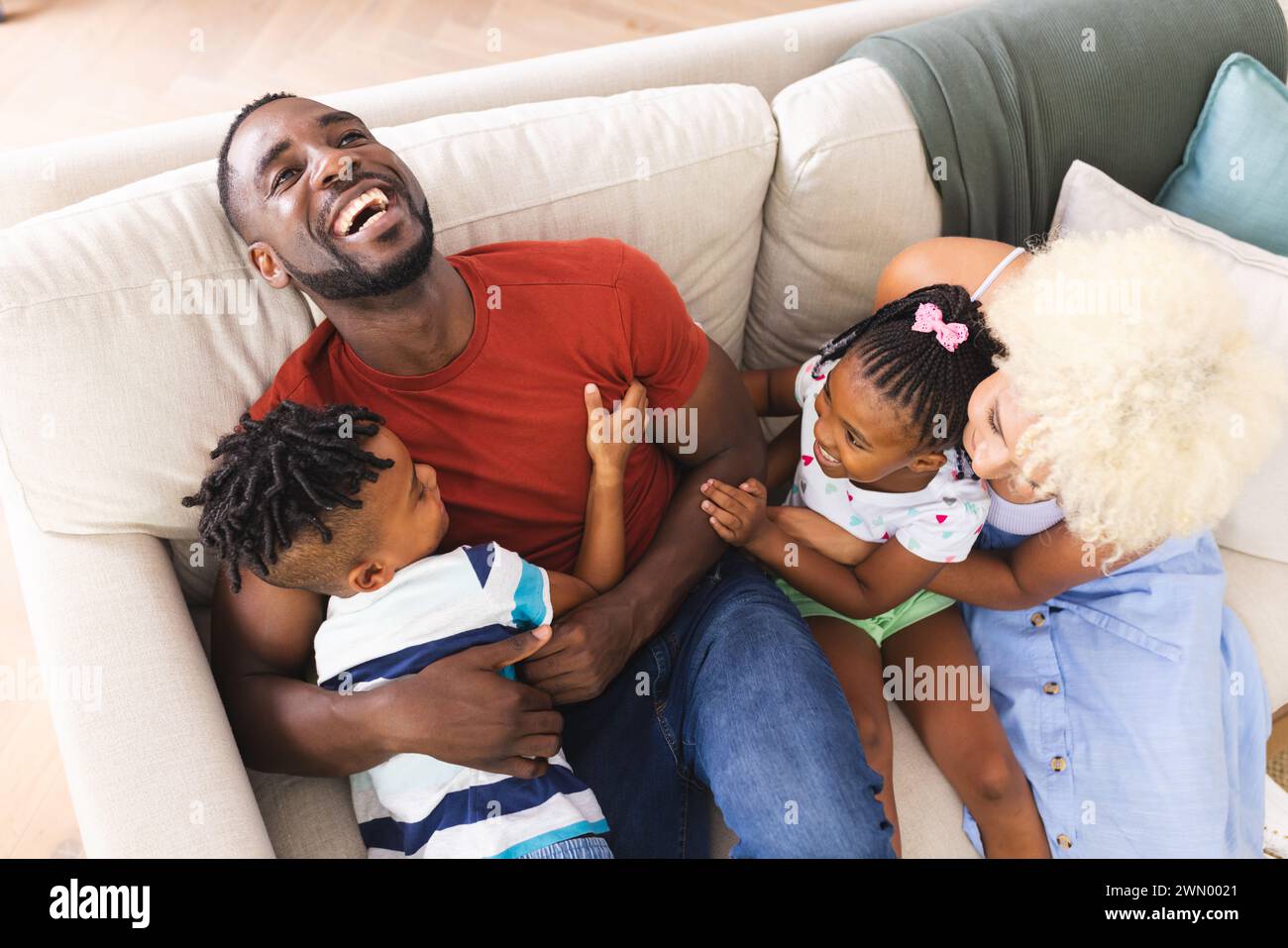 African American father enjoys time with his son and daughter on a couch Stock Photo