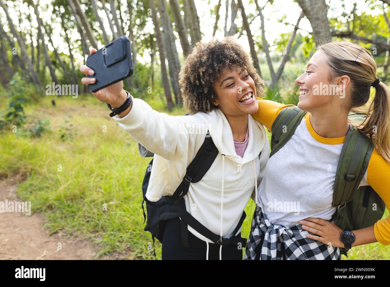 Biracial and Caucasian women take a selfie during a hike on a hike Stock Photo