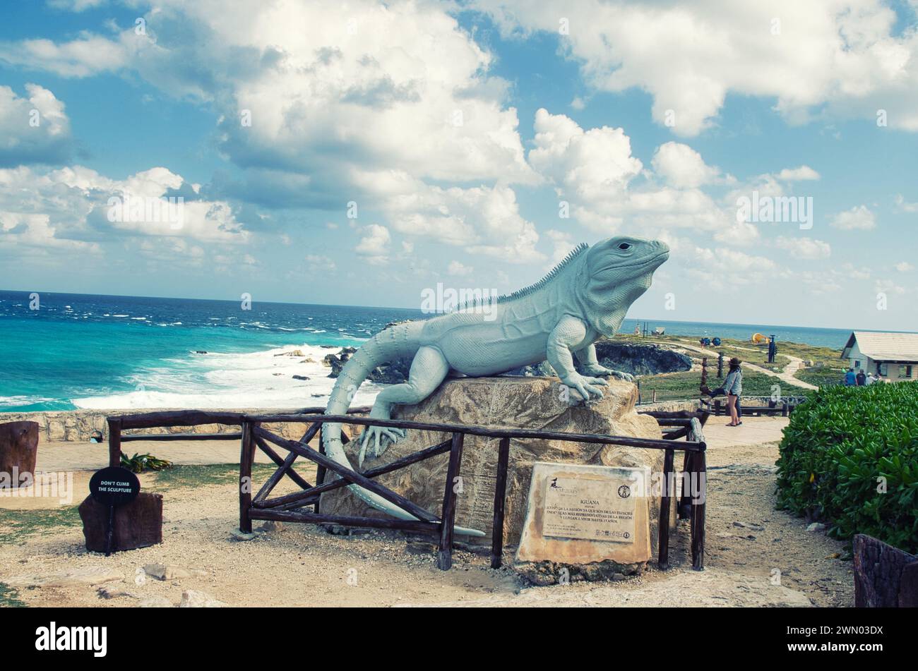 ISLA MUJERES, MEXICO- February 20,2016: Statue of large black spiny tailed iguana on Punta Sur, Isla Mujeres Island with Caribbean Sea in background. Stock Photo