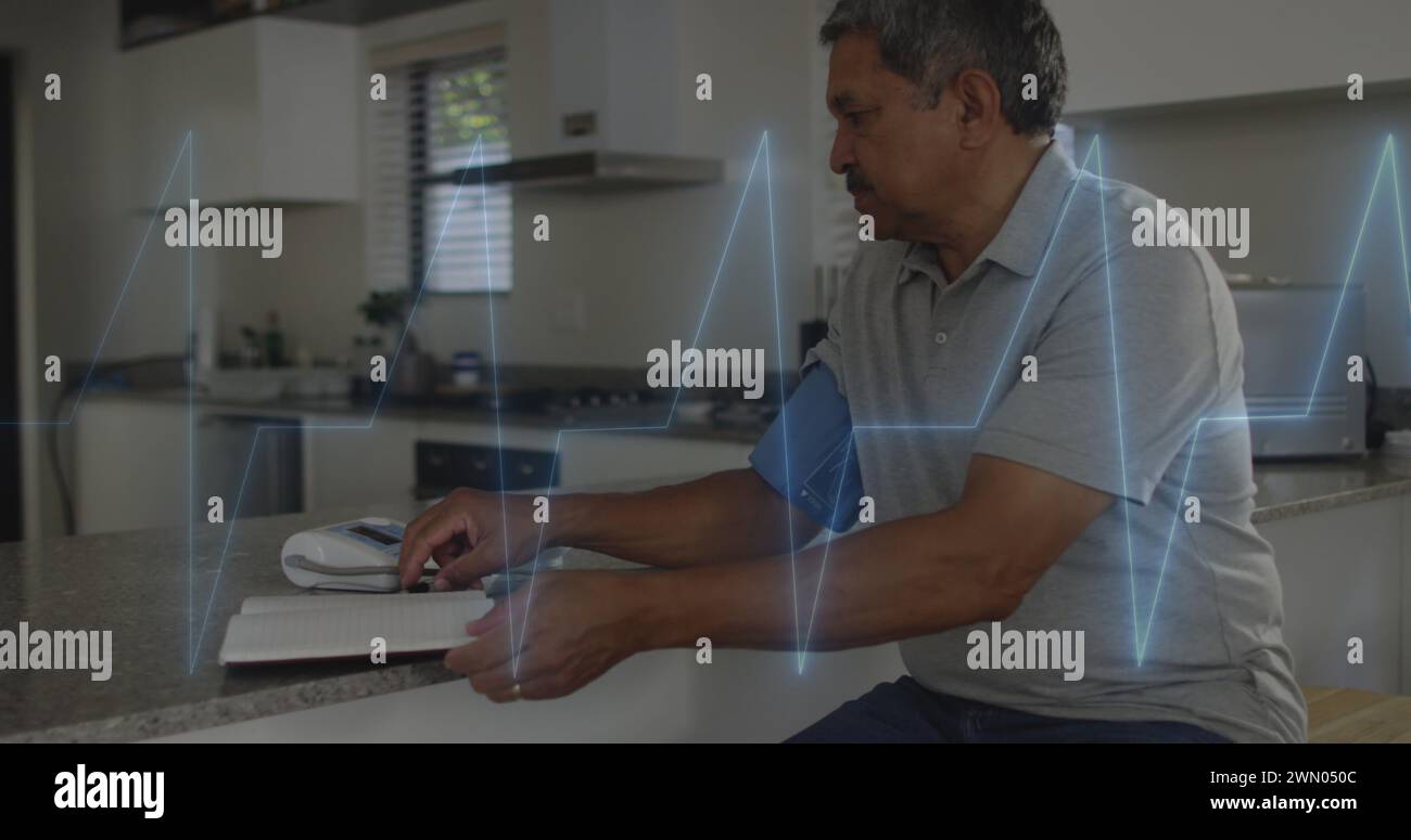 Image of cardiogram over senior biracial man measuring blood pressure Stock Photo