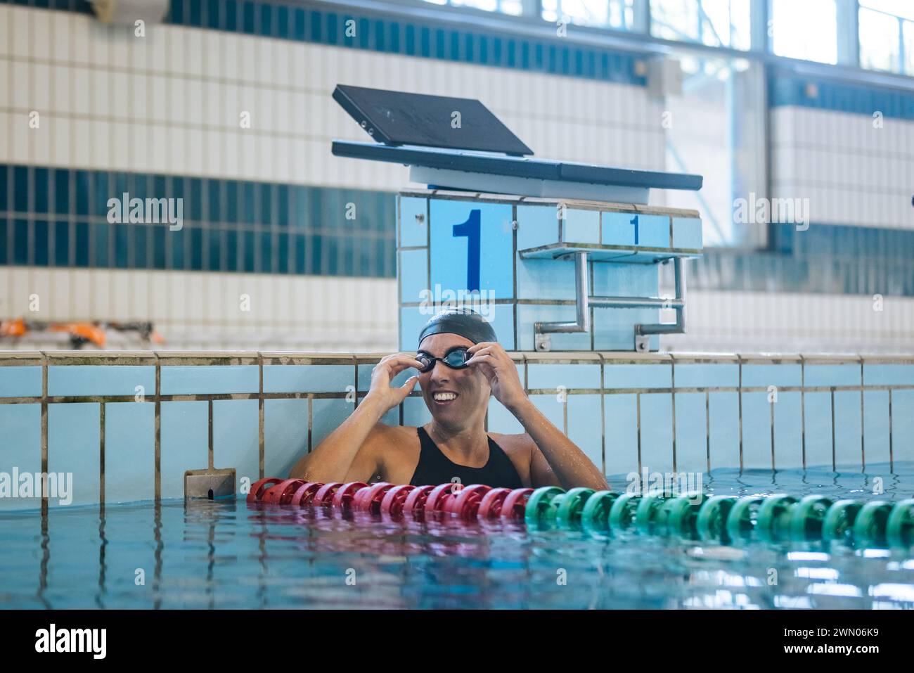 Woman swimmer happy at the finish of a race in the pool at competition ...
