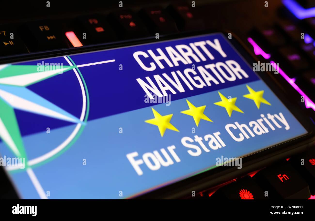 Viersen, Germany - January 9. 2024: Smartphone screen with logo lettering of Charity Navigator organization on computer keyboard Stock Photo