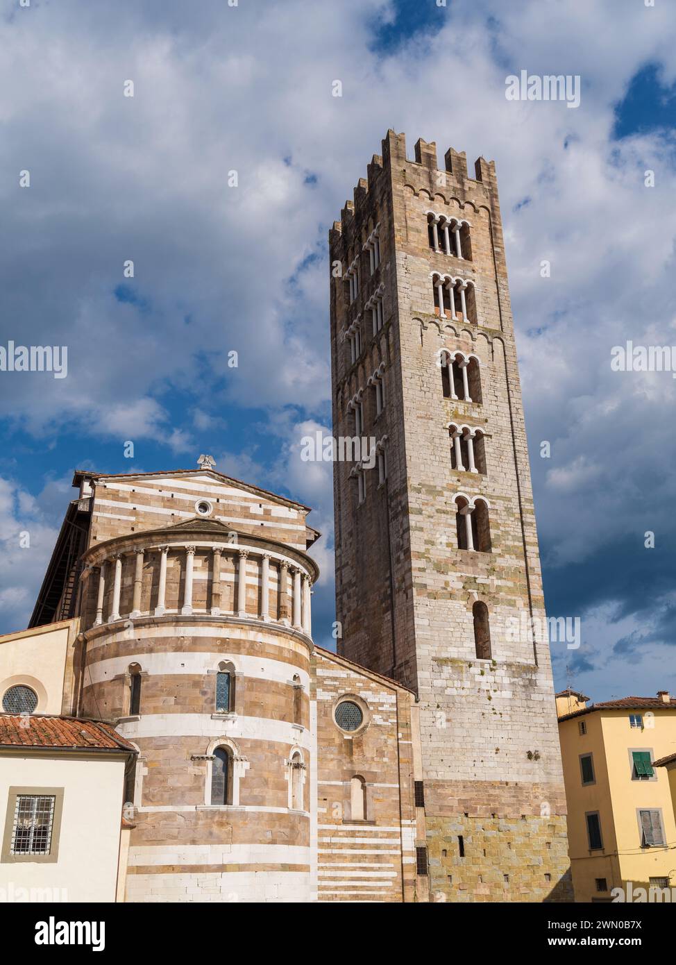 Basilica of San Frediano (St Fredianus) romanesque apse with medieval bell tower among clouds, in Lucca historical center Stock Photo
