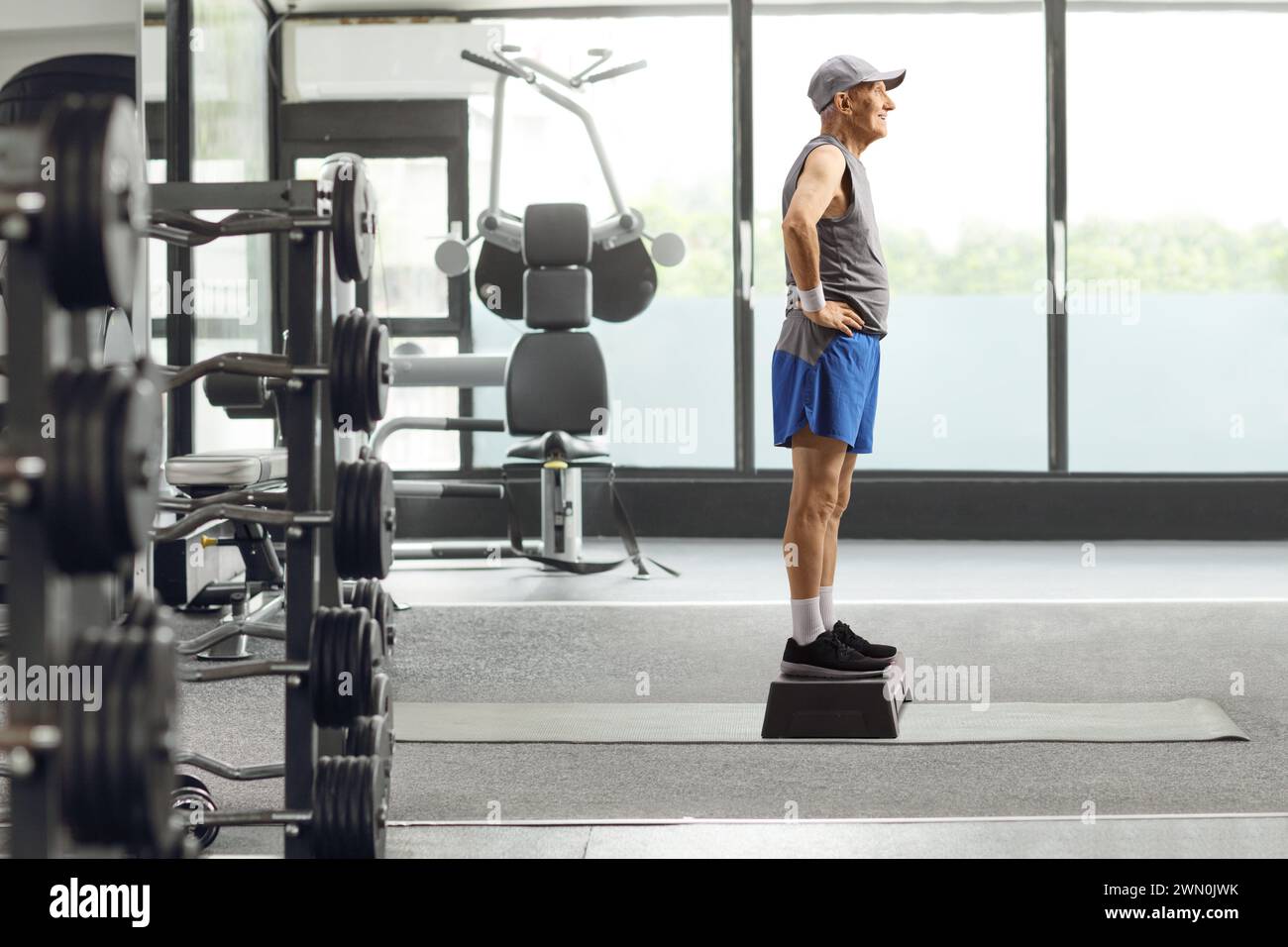 Full length profile shot of an elderly man at a gym standing on a step aerobic platform Stock Photo