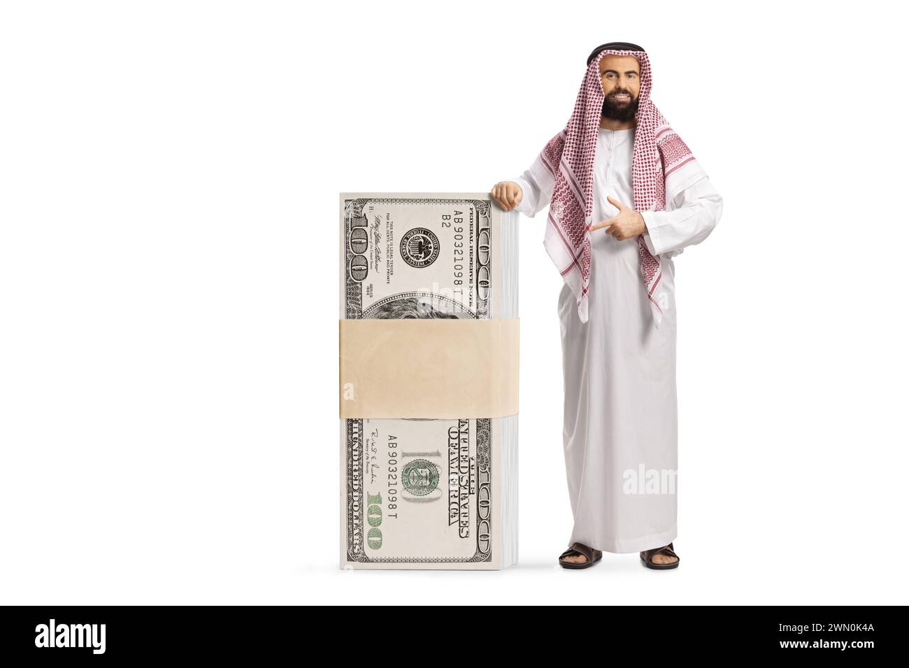 Saudi arab man pointing at a big stack of money isolated on white background Stock Photo
