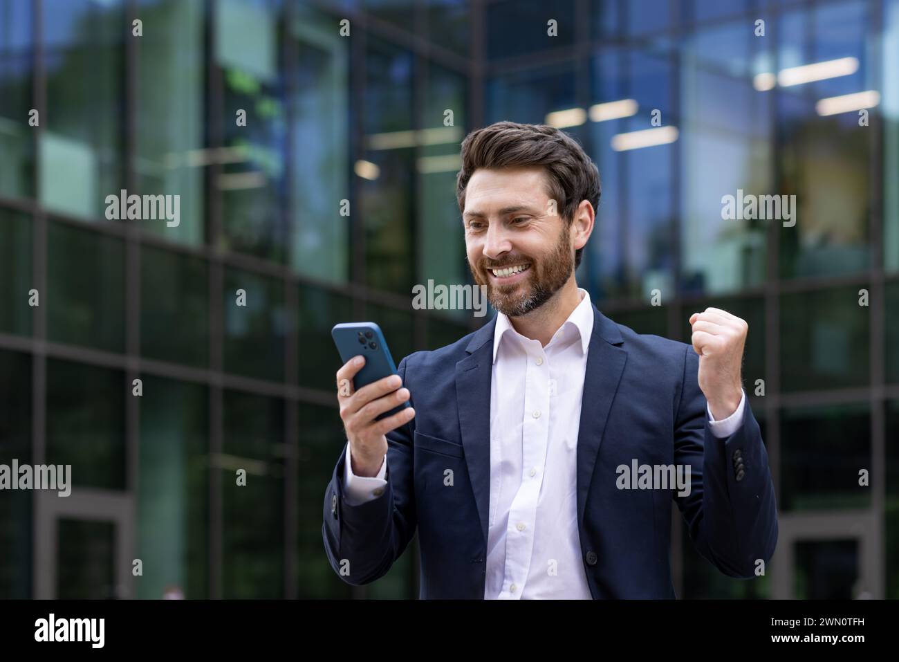 A young, professional businessman celebrates a successful deal with a ...
