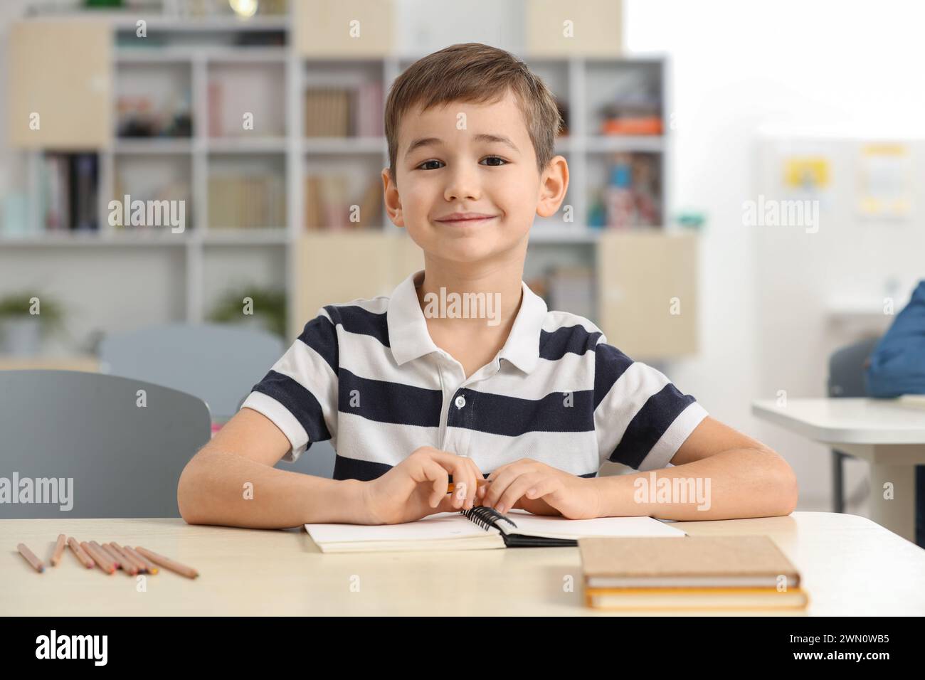 Portrait of cute little boy studying in classroom at school Stock Photo ...