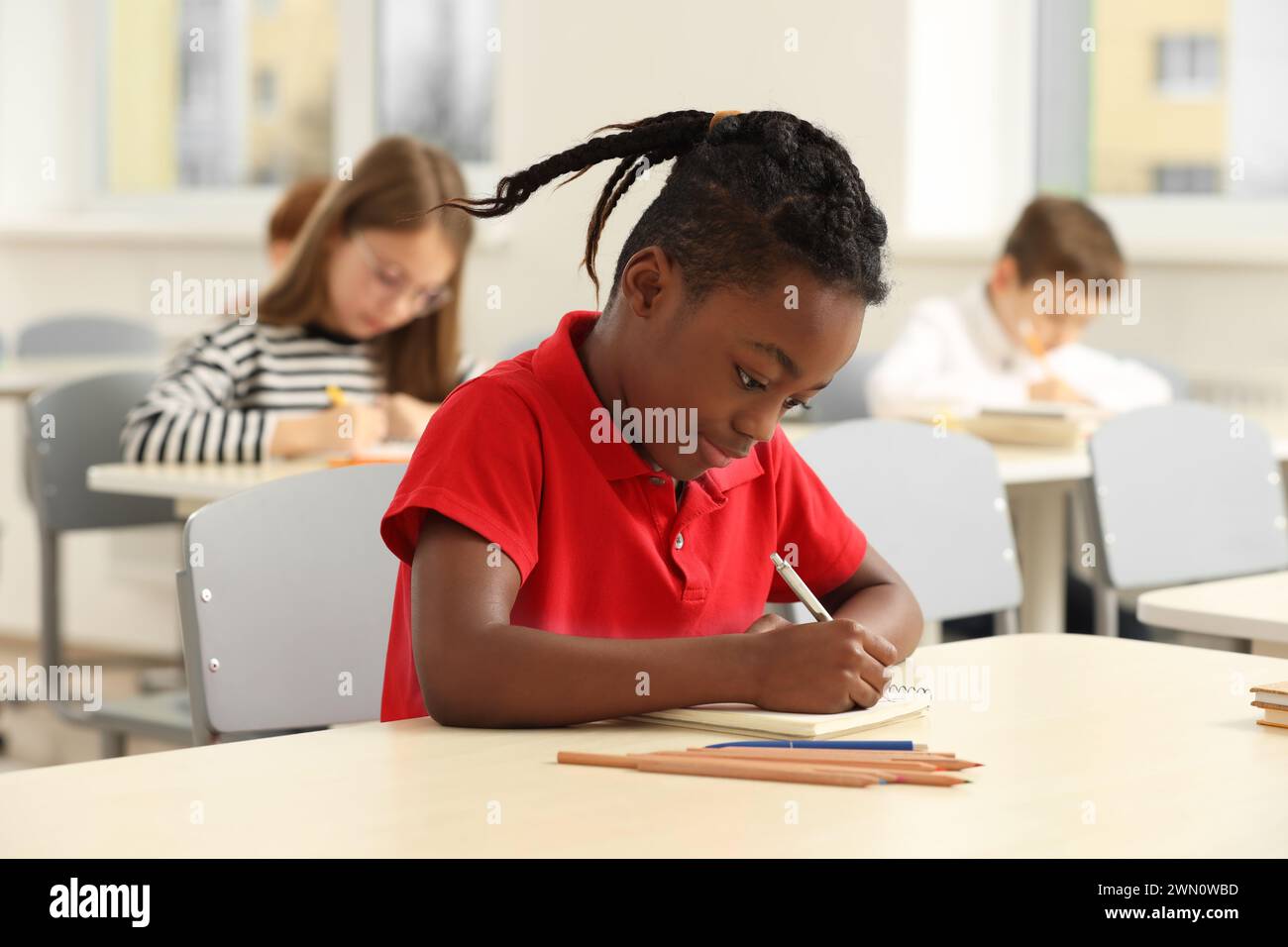 Portrait of cute little boy studying in classroom at school Stock Photo ...