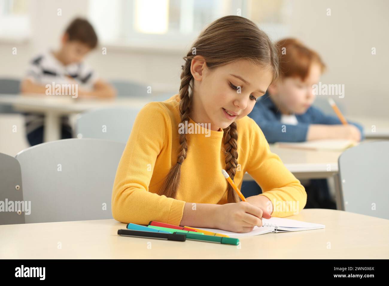 Smiling little girl studying in classroom at school Stock Photo - Alamy