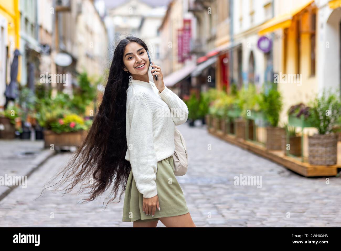 Portrait of a beautiful young Indian woman with long hair walking on a ...
