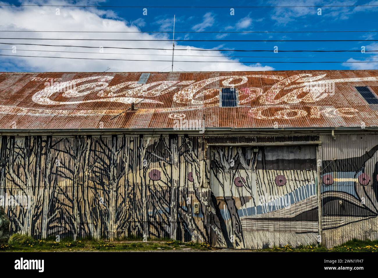 A faded Coca Cola sign painted on a tin roof on a building in Puerto Natalas,, Chile, South America. Stock Photo