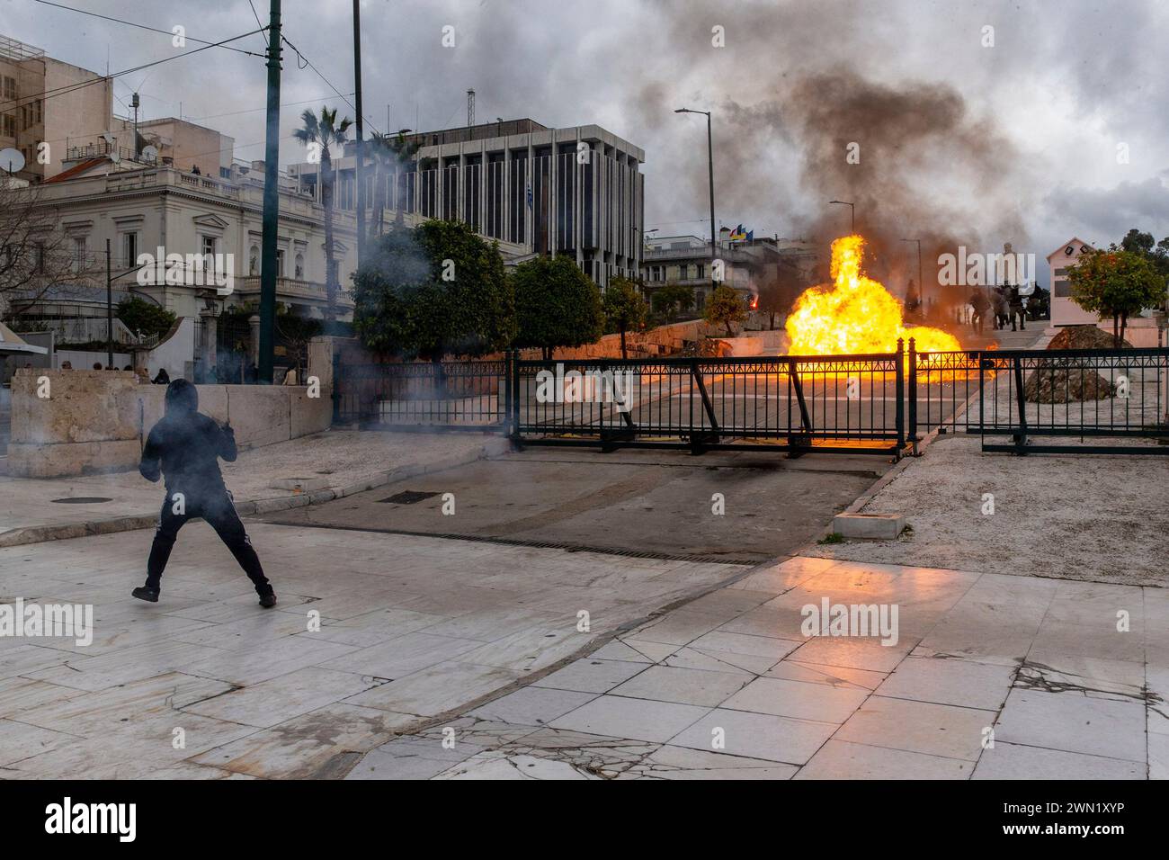 (240229) -- ATHENS, Feb. 29, 2024 (Xinhua) -- A protestor throws Molotov cocktails during a demonstration to mark the first anniversary of the country's deadliest-ever train crash in Athens, Greece, Feb. 28, 2024. Greece was hit by a 24-hour nationwide strike on Wednesday, paralyzing public services including transport and hospitals. The trade union-led strikes were called to protest low salaries amid high living costs. In central Athens, around 20,000 protestors marched on Wednesday to mark the first anniversary of the country's deadliest-ever train crash, which happened one year ago in Stock Photo