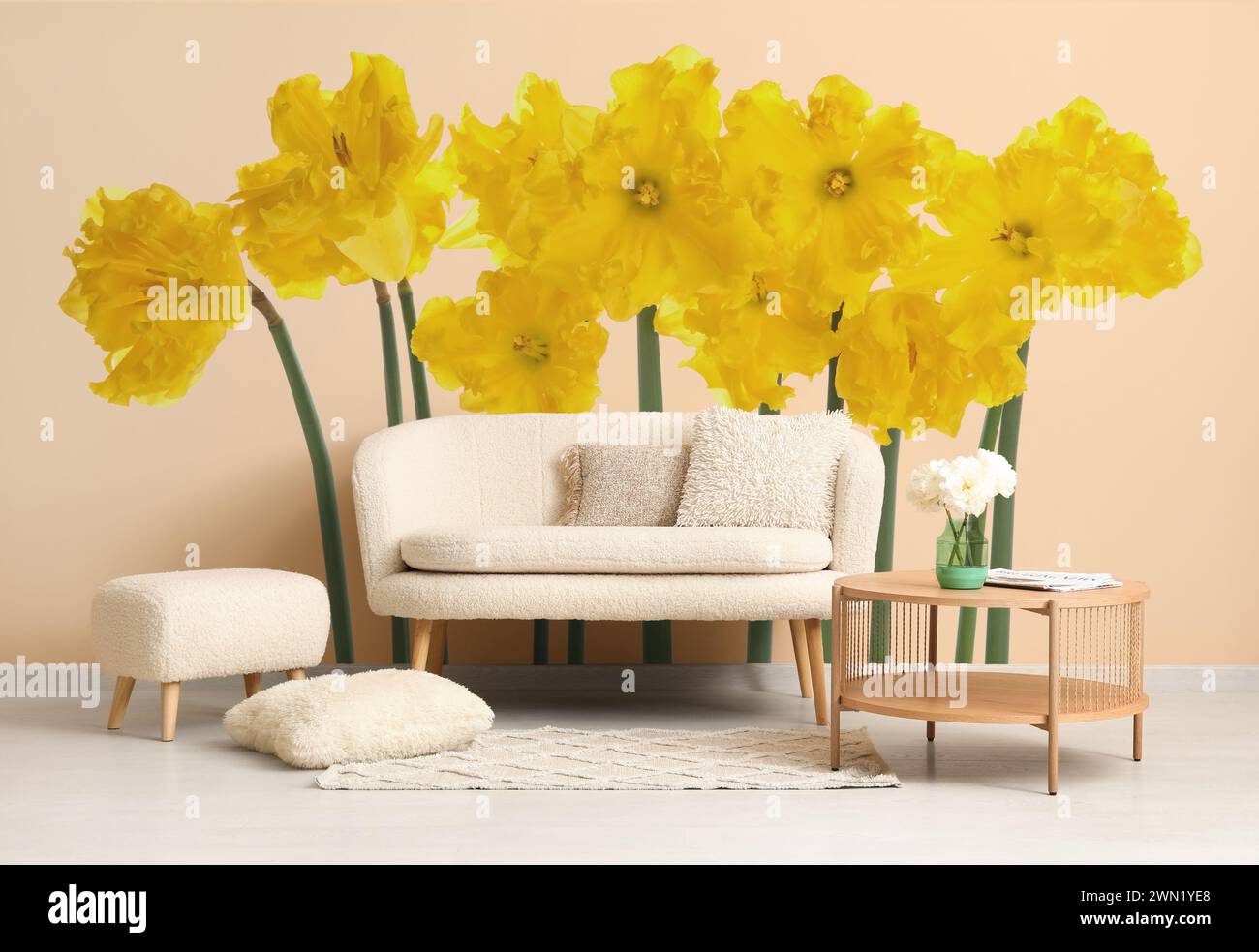 Stylish interior of room with grey sofa and beautiful daffodil flowers ...