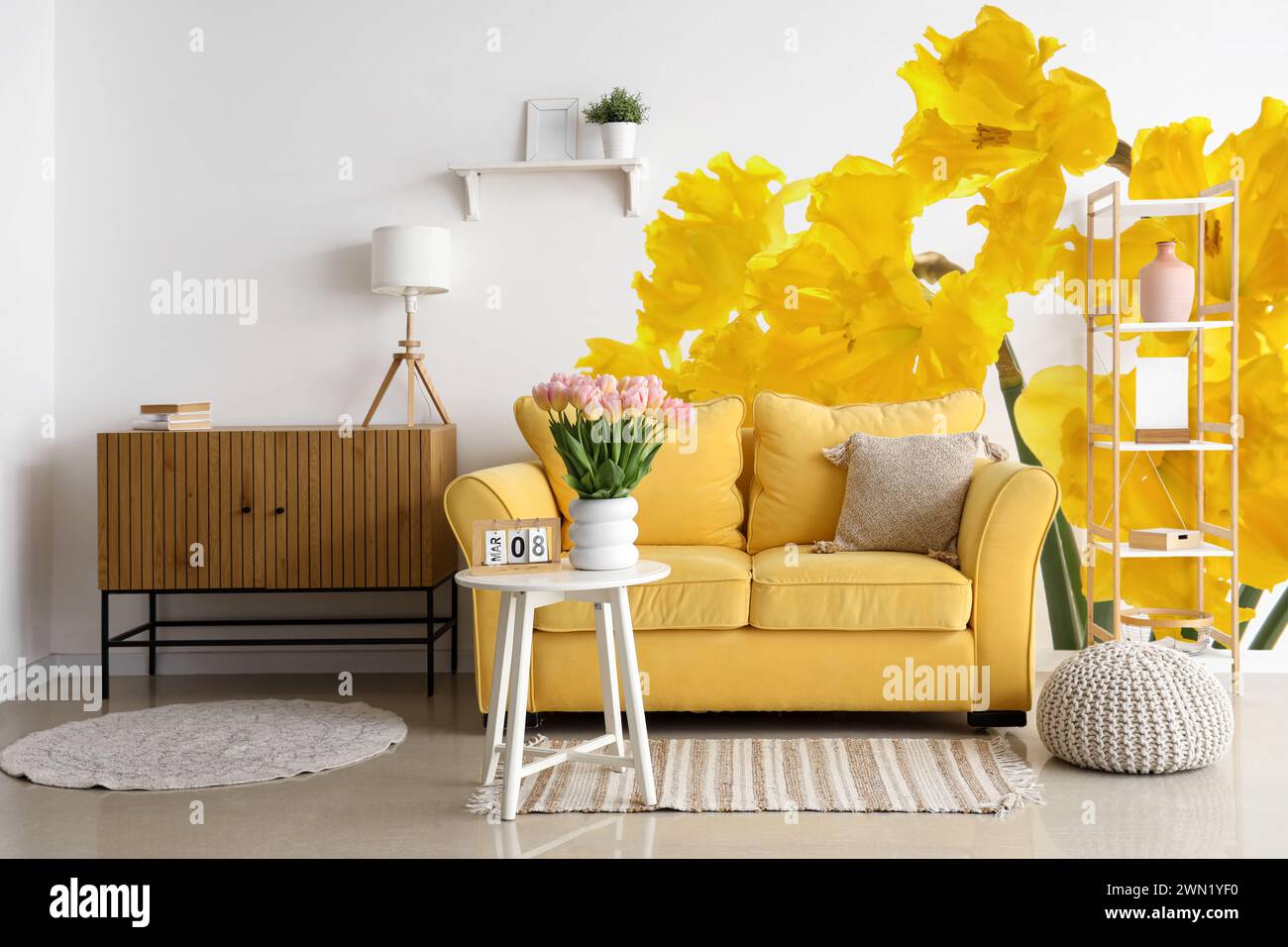 Stylish interior of room with yellow sofa and beautiful daffodil ...