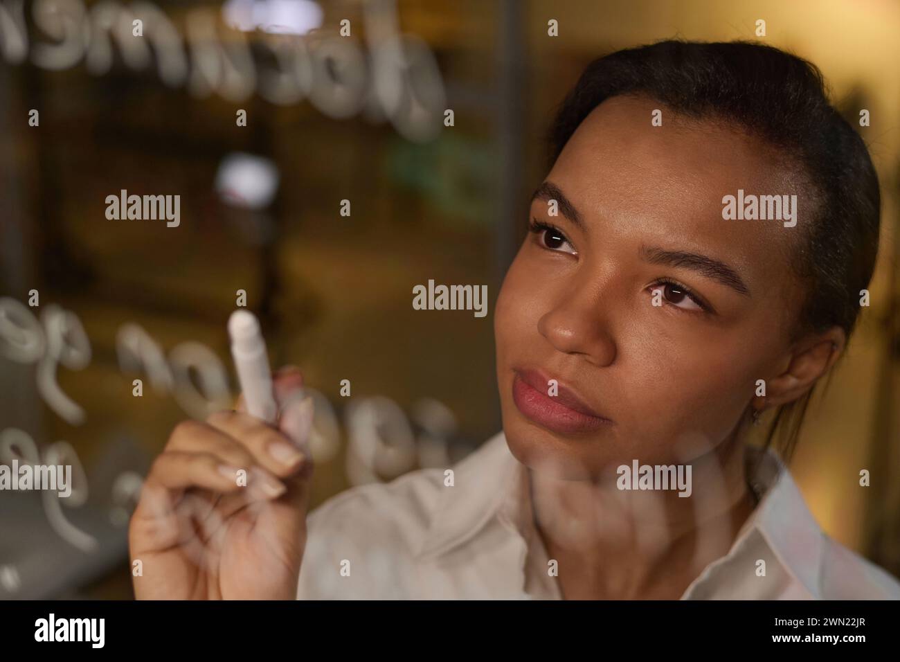 Young Black Woman developing code writing it on glass wall Stock Photo