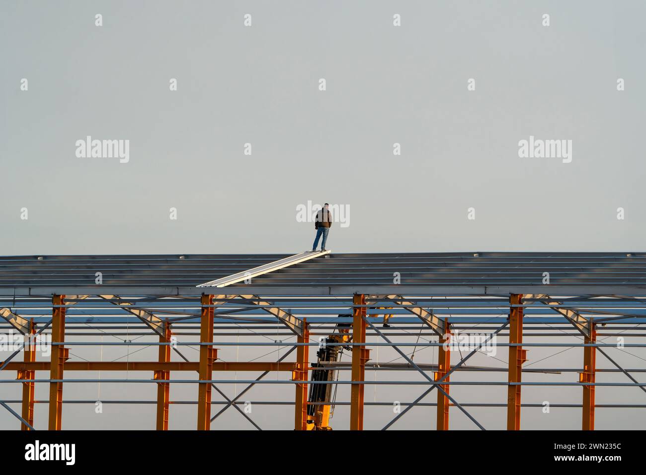 A person standing on a steel construction building Stock Photo