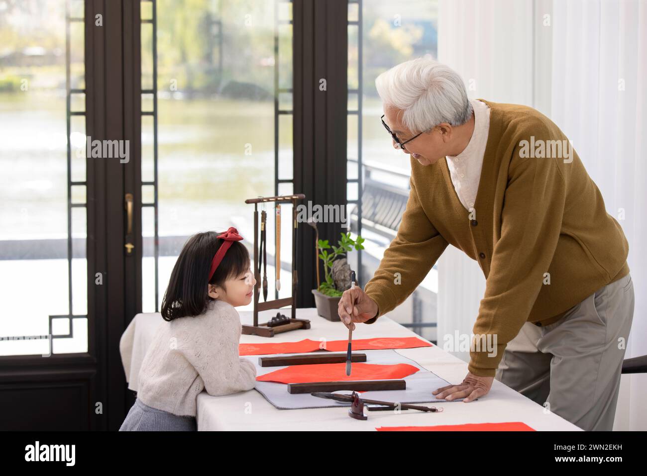Grandfather and Granddaughter Writing New Year Couplets Stock Photo