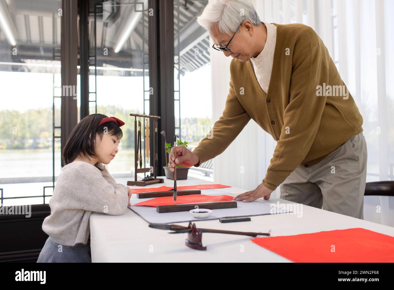 Grandfather and Granddaughter Writing New Year Couplets Stock Photo