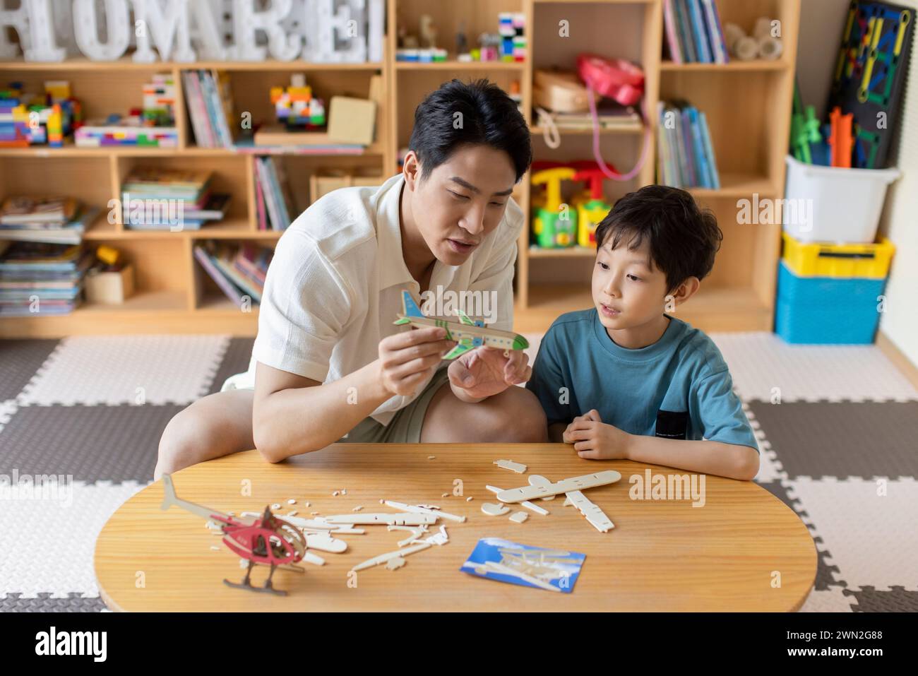 Young father an son making wooden plane Stock Photo