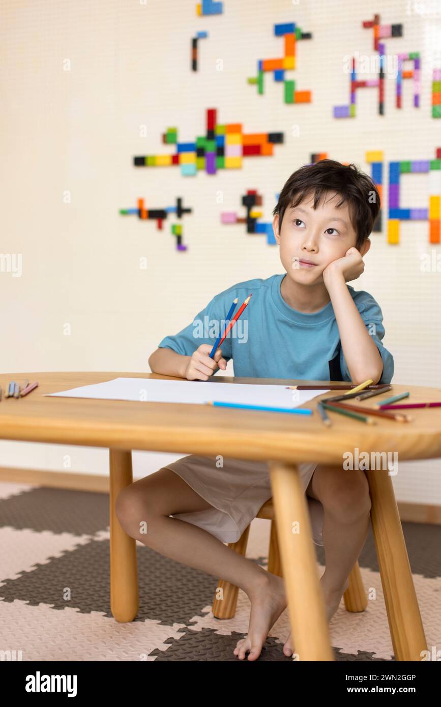 Cute boy thinking in classroom Stock Photo