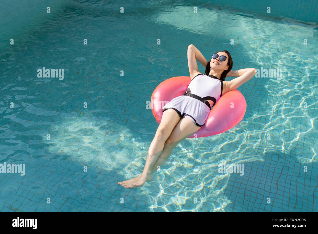 Happy young woman relaxing in swimming pool Stock Photo