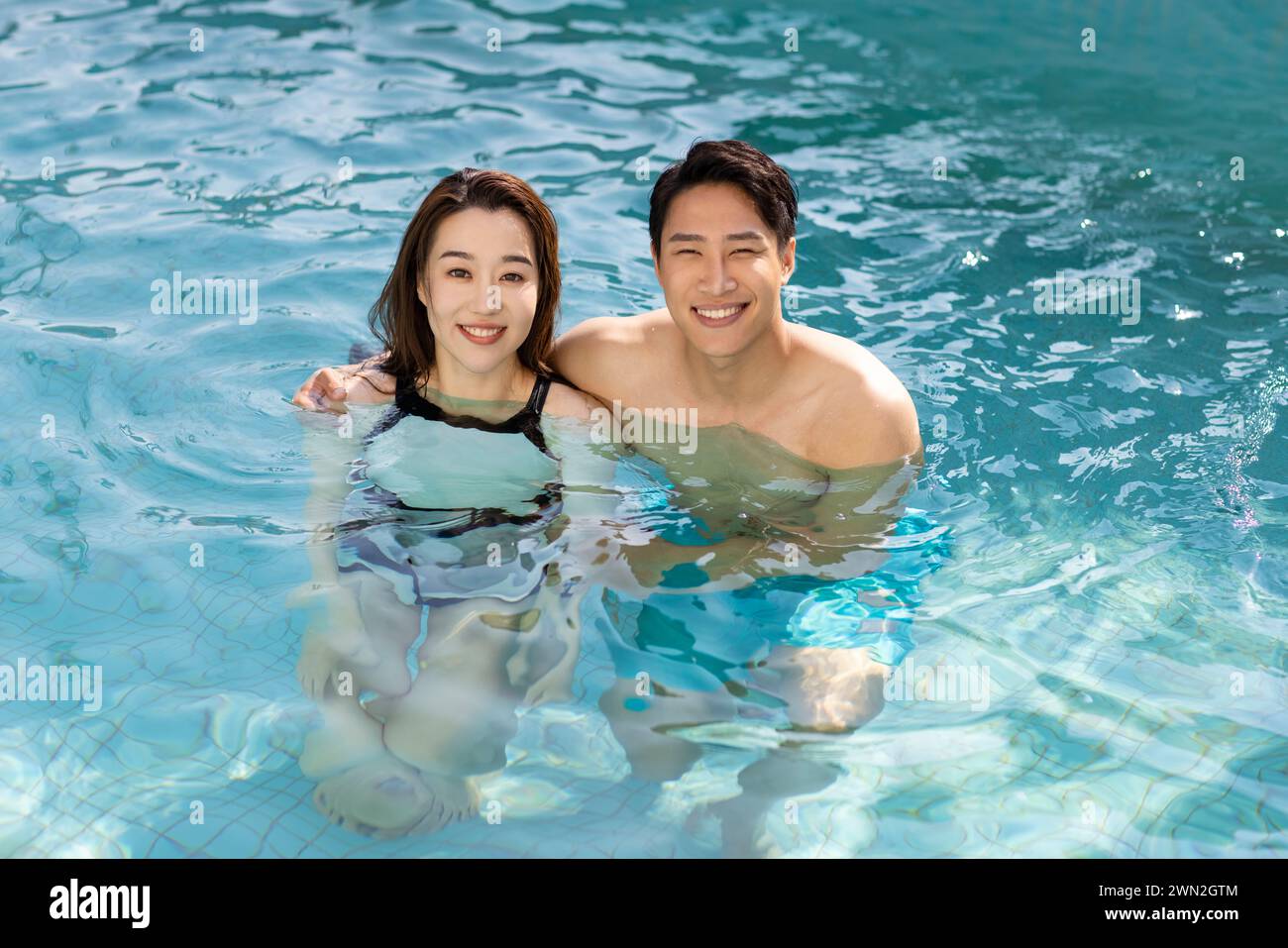 Happy young couple having fun in swimming pool Stock Photo