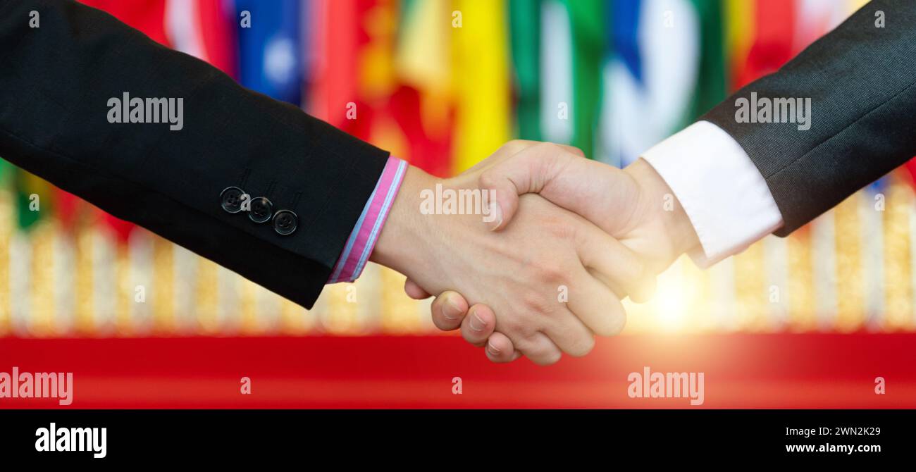 Businessmen shaking hands in front of the multi - national flags Stock ...
