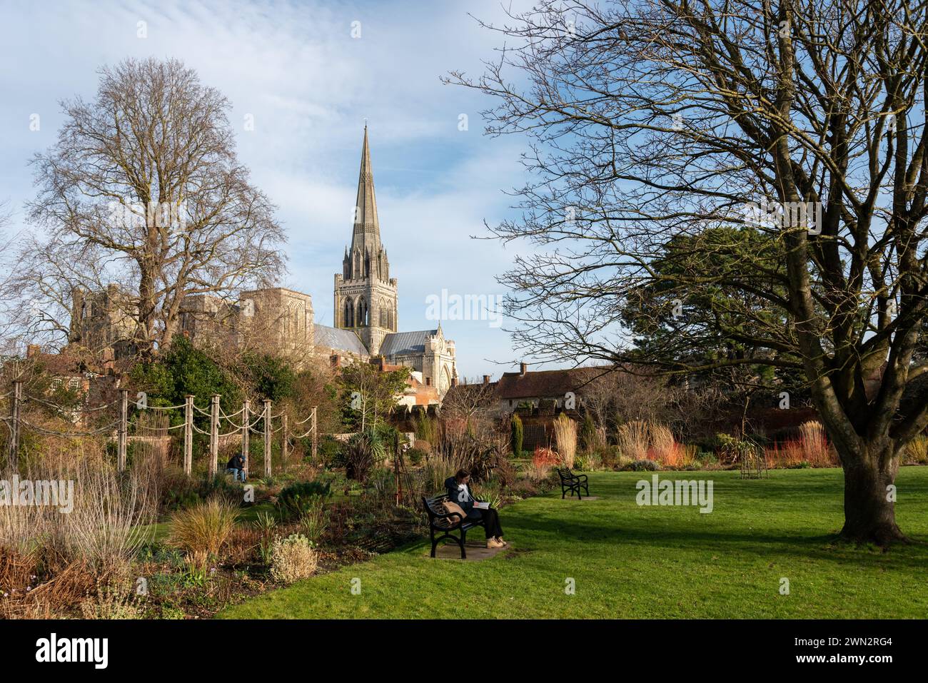 People relaxing in a park with Chichester Cathedral as a backdrop. March 2024. Stock Photo