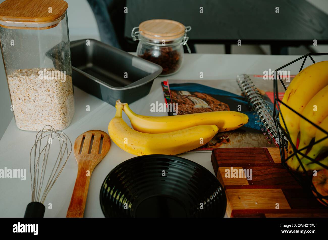 Gearing up for baking success: Fresh banana, pot, and cookbook in frame Stock Photo