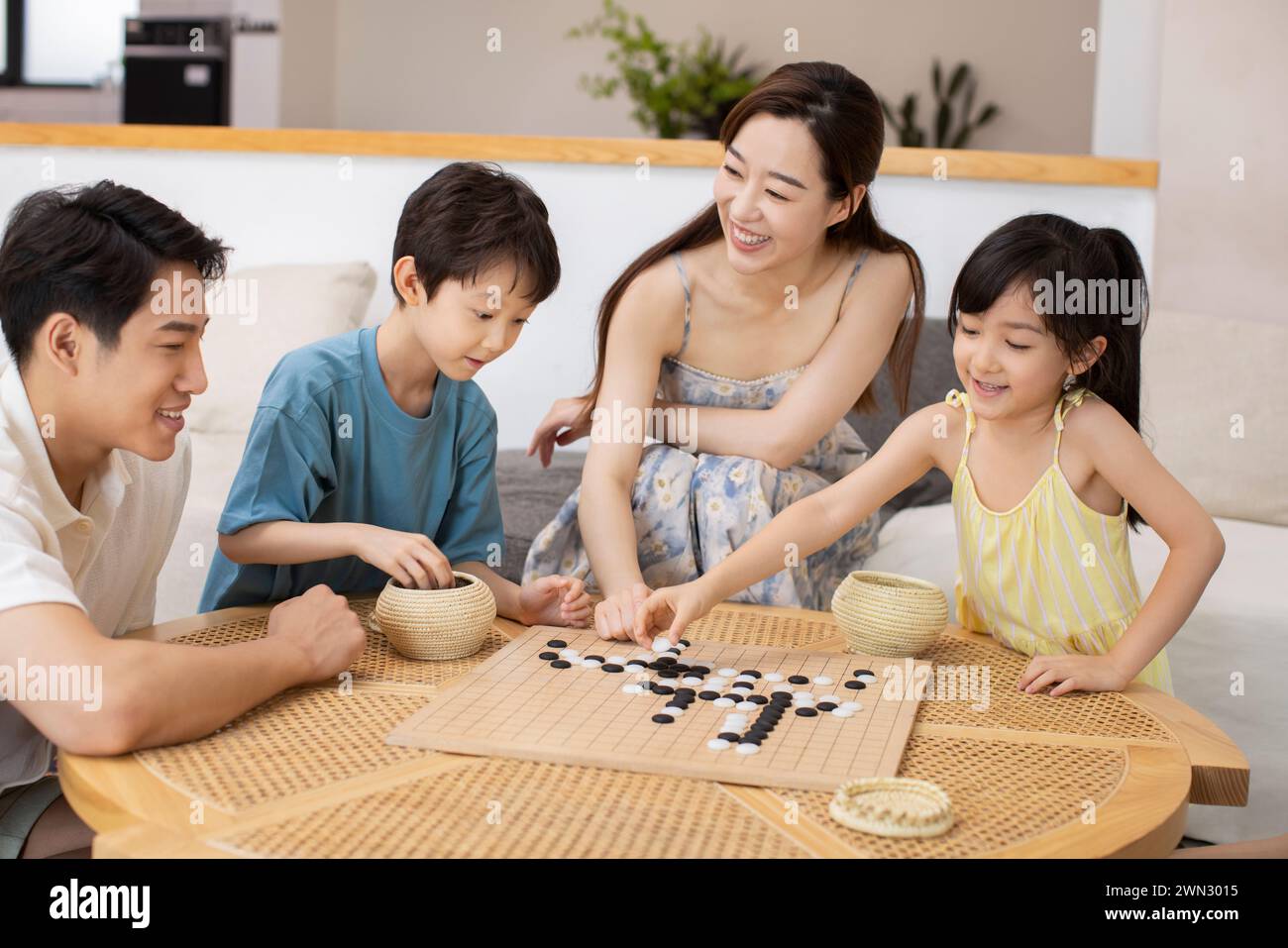 Happy family playing the game of go Stock Photo