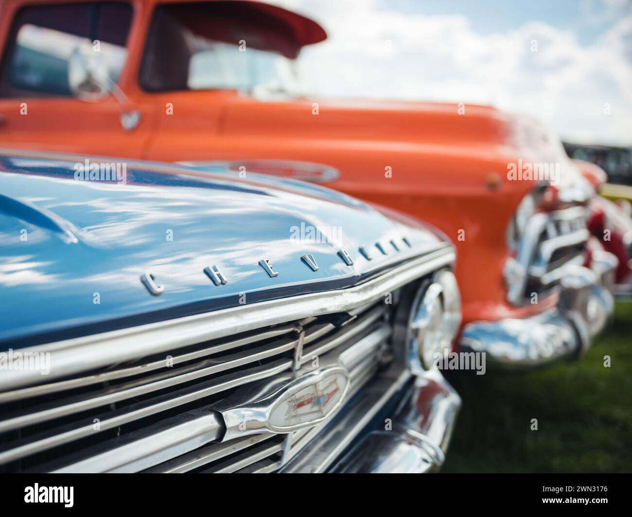 Chevrolets of the 1960 - front parts of '60 Impala and '57 Chevrolet Task Force light truck. Close-up selective focus image of Impala and truck. Stock Photo