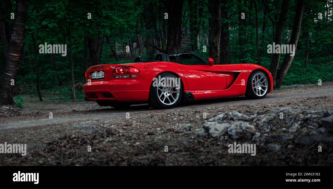 red Dodge Viper in a forest. Rear three quarter view of american roadster sports car Stock Photo