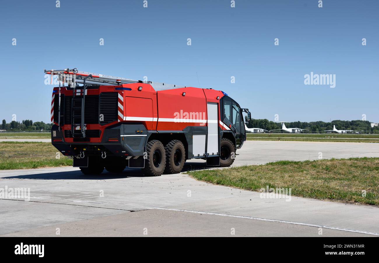 Airport fire truck on a sunny day. Modern firefighter equipment at duty on the airfield. Modern fire engine for airport operations. Stock Photo