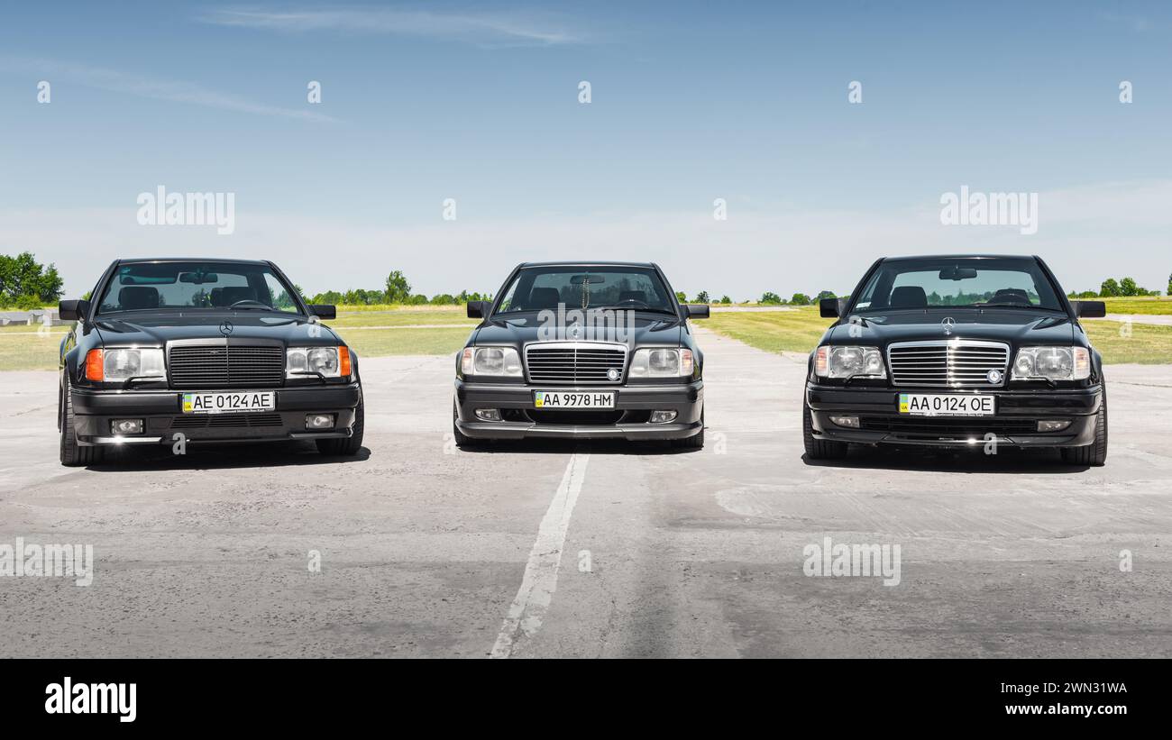 three Mercedes-Benz E-class coupes C124 (W124) model. 1980s-1990s Mercedes cars on a sunny day at airfield. Stock Photo