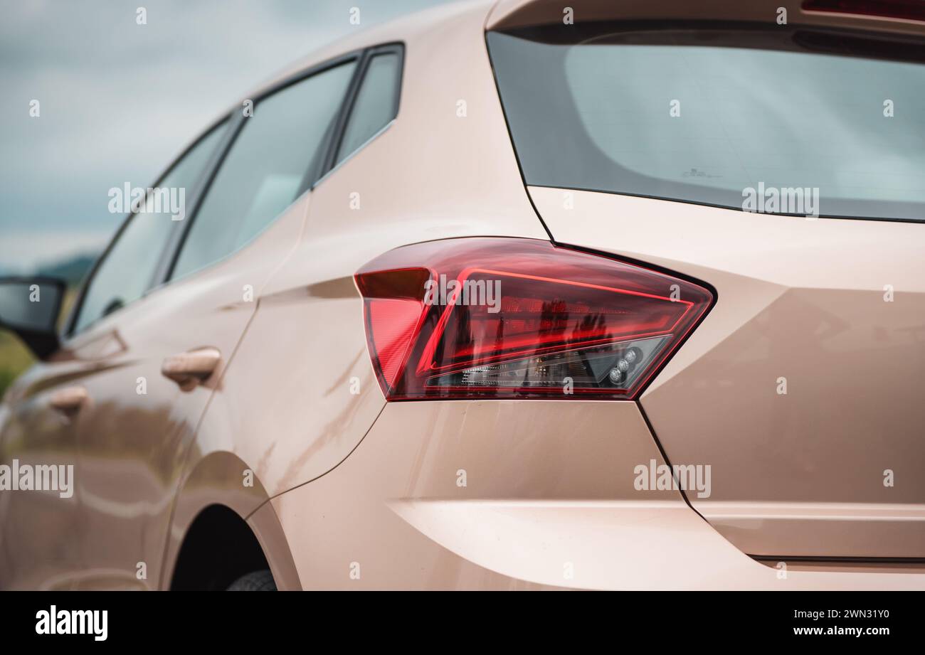 close up view of rear quarter panel of beige colored SEAT hatchback. Image of compact skin colored car on a cloudy day. Stock Photo