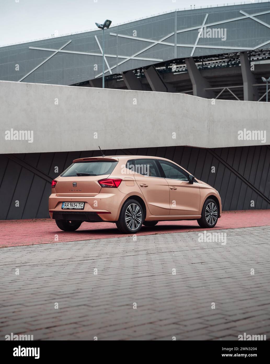 beige SEAT Ibiza in front of modern building. Rear three quarter view of compact pale ivory spanish hatchback parked in urban setting. Stock Photo
