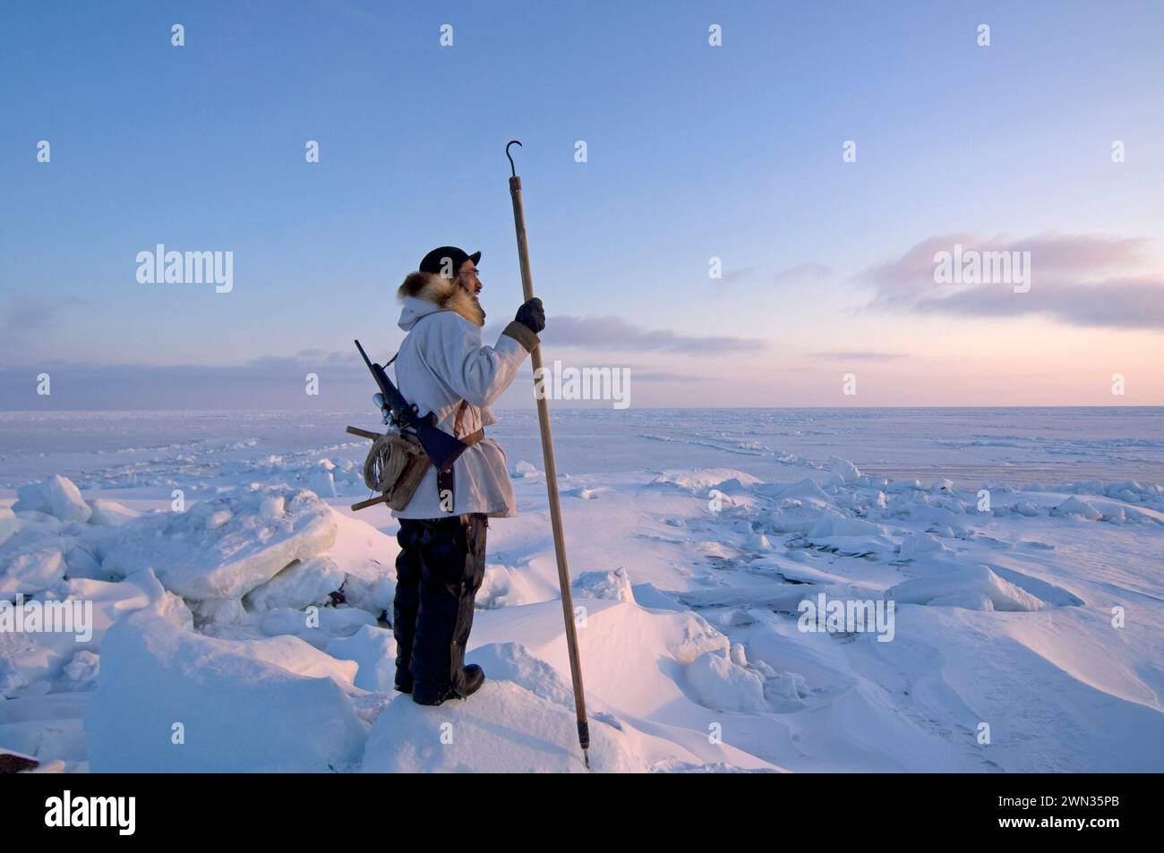 Inupiaq hunter seal hunting near open lead  at the point of Point Hope Tigia Arctic Alaska Stock Photo