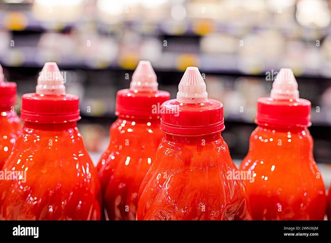 ketchup sauce packaged in bottles on shelves in a supermarket Stock Photo