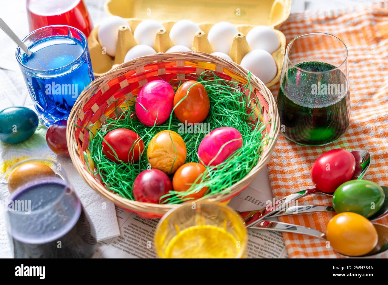 Augsburg, Bavaria, Germany - 28 February 2024: Easter nest with colorful eggs on a table during egg dyeing at Easter *** Osternest mit bunten Eiern auf einem Tisch beim Eierfärben zu Ostern Stock Photo