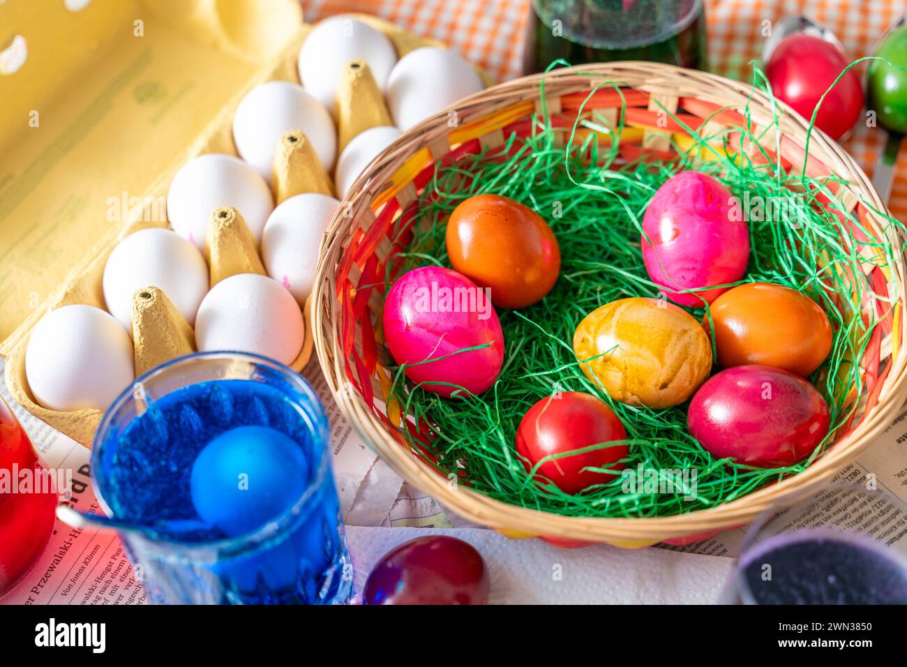 Augsburg, Bavaria, Germany - 28 February 2024: Easter nest with colorful eggs on a table during egg dyeing at Easter *** Osternest mit bunten Eiern auf einem Tisch beim Eierfärben zu Ostern Stock Photo