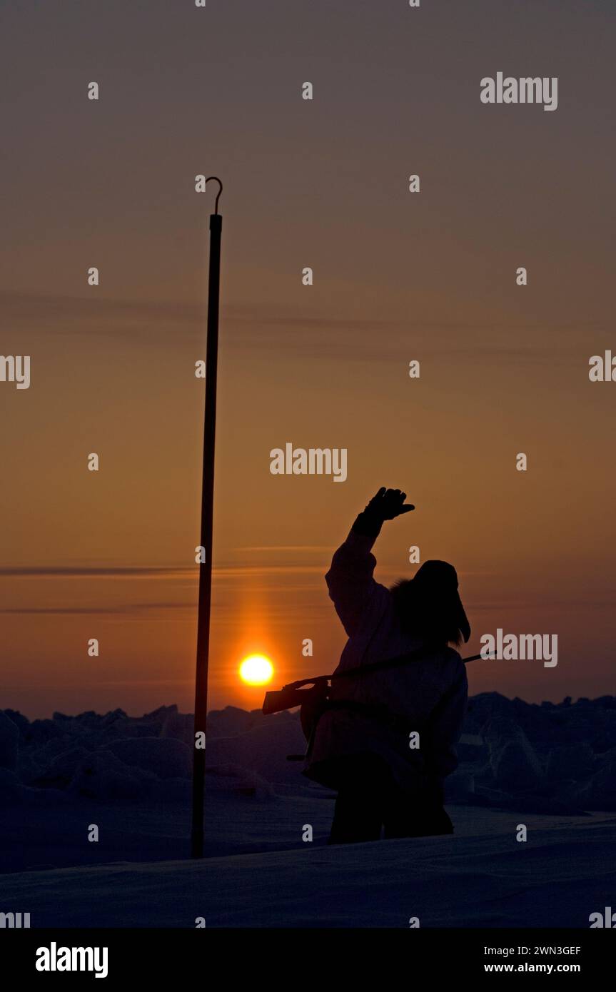 Inupiaq hunter seal hunting near open lead holding sun at sunset at the point of Point Hope Tigia Arctic Alaska Stock Photo