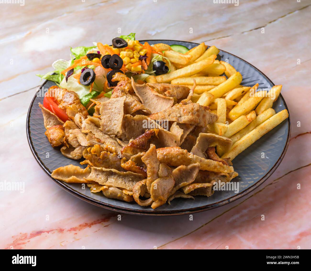 Chicken Shawarma plate with salad, fries served in a dish isolated on grey background side view of arabian fastfood, mallorca, balearic islands, spain Stock Photo