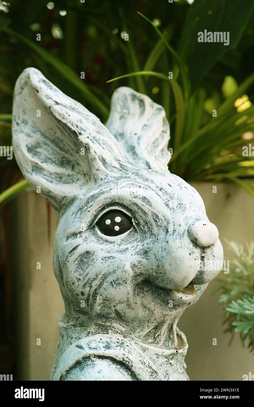 Closeup of an Adorable Stone Easter Bunny Sculptures in the Garden Stock Photo