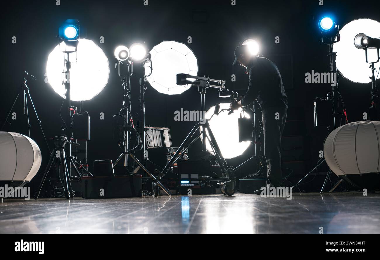 A Man Assembling Powerful Modern LED Video and Photo Lighting Inside Dark Production Studio Stock Photo