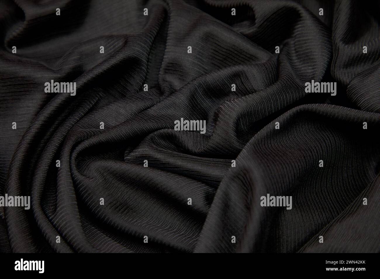 Close-up of black textured fabric swatch on dark background Stock Photo