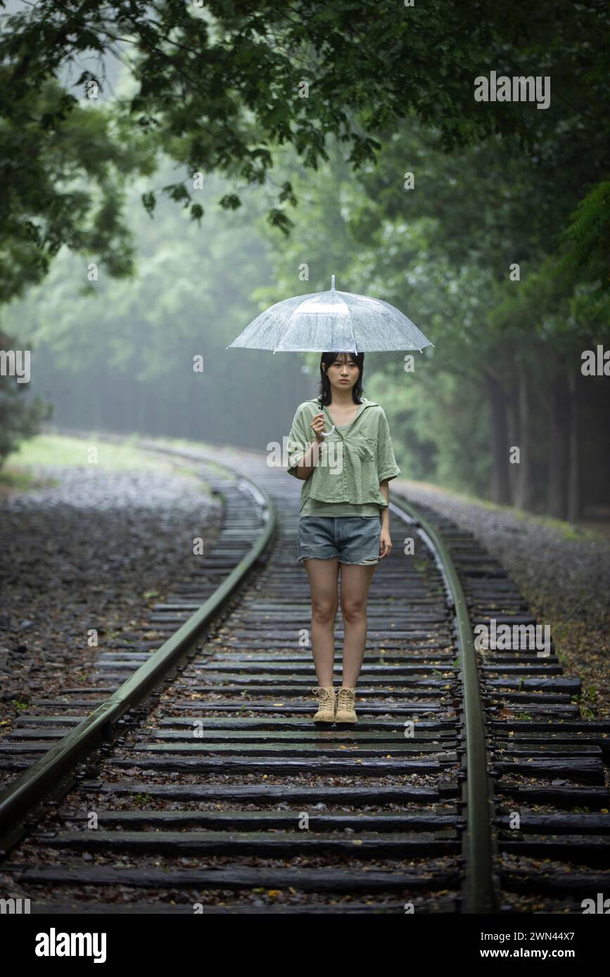 Young woman holding umbrella Stock Photo