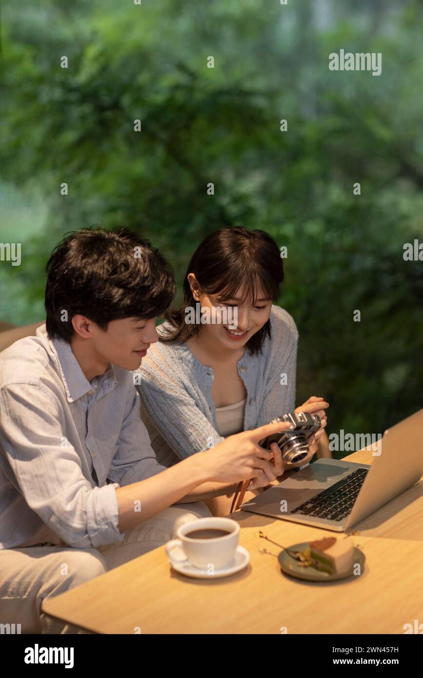 Young couple checking photos in café Stock Photo